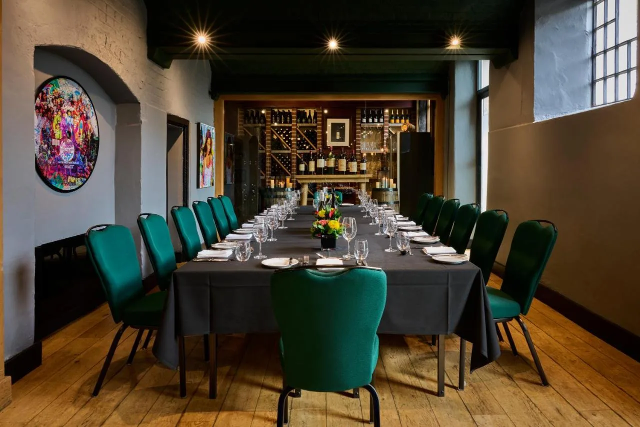 long private dining table with green chairs at Malmaison Oxford, Oxford